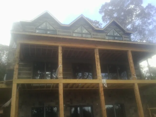 Dormers and porch framing on a large log home under construction — Roof Coating work by our crew in Nanjemoy